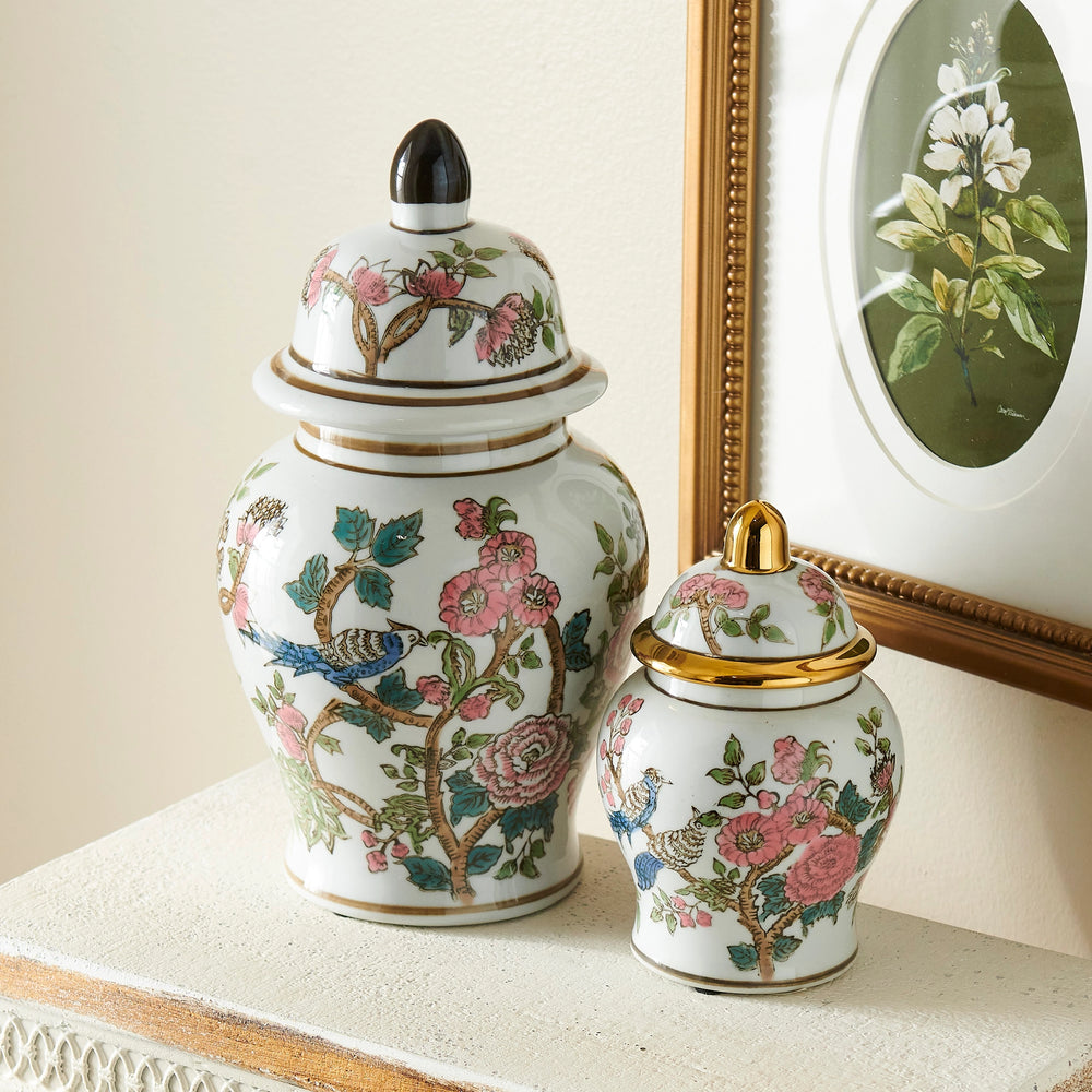 Two decorative ceramic jars with floral and bird patterns on a surface.