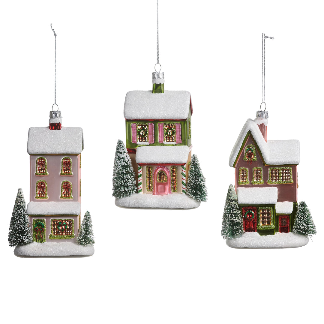 Three Christmas house ornaments with snow and trees on a white background