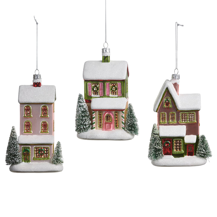 Three Christmas house ornaments with snow and trees on a white background