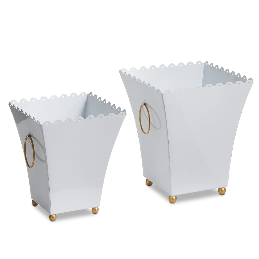 Two white trash cans with scalloped edges and gold accents on a white background