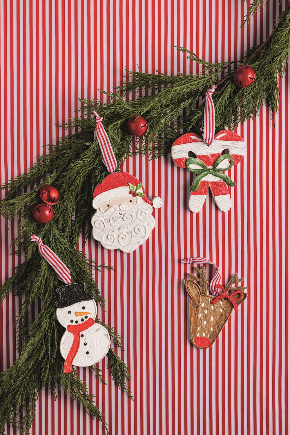 Decorative Christmas garland with ornaments on a red and white striped background. 