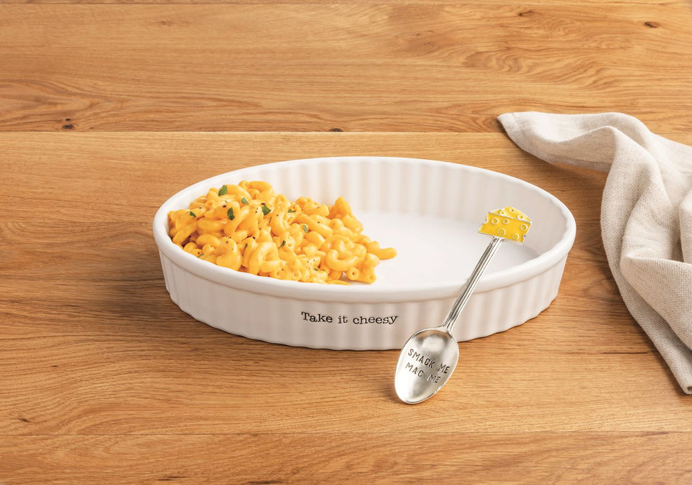 white "take it easy" oval dish with mac and cheese and silver spoon on wooden background