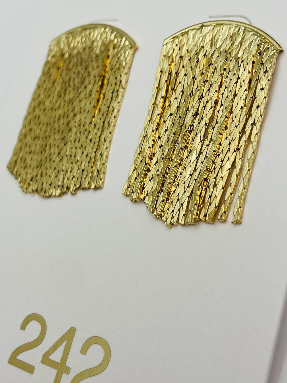 Gold fringe earrings on a white background with number 242.
