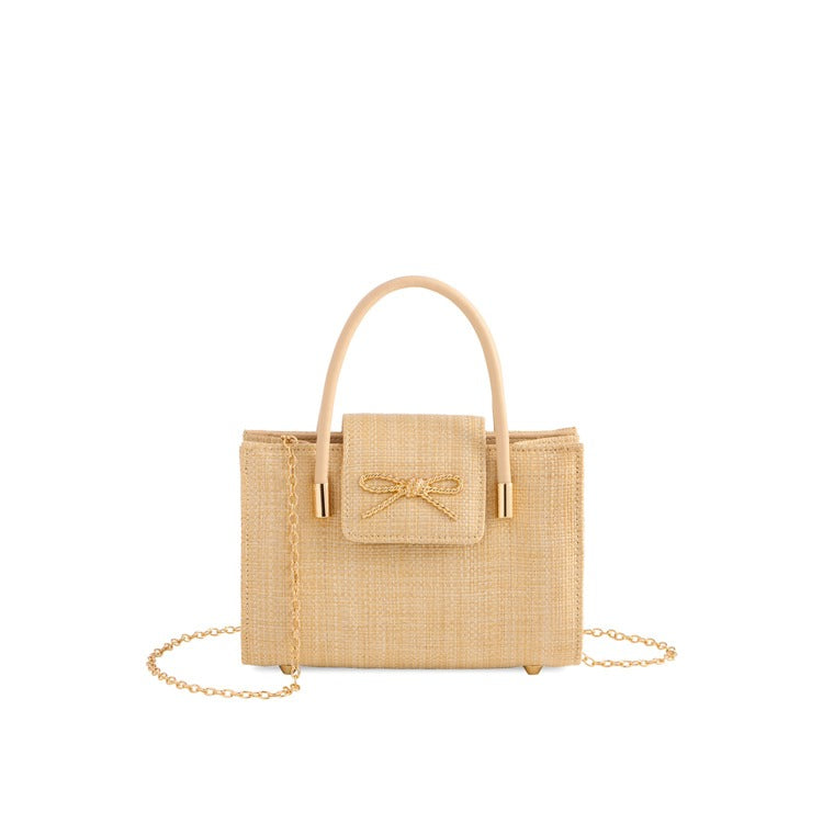 Ivory woven bow clutch handbag with top handle and gold chain strap, featuring textured fabric and gold hardware | Walker Boutique