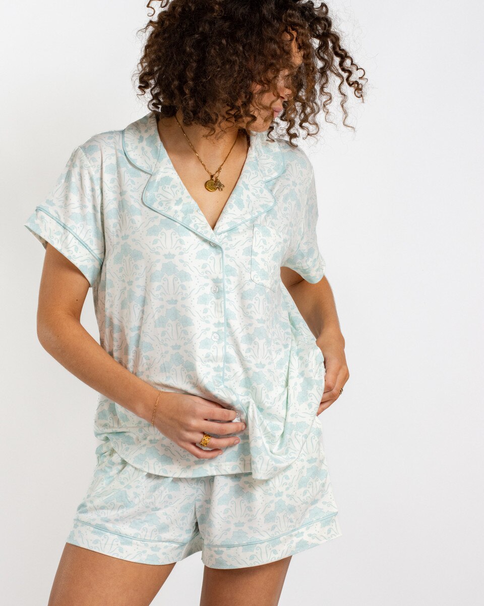 Woman wearing a light blue pajama set with a white background