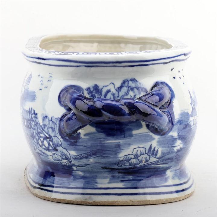 Blue and white ceramic pot with landscape design on a white background