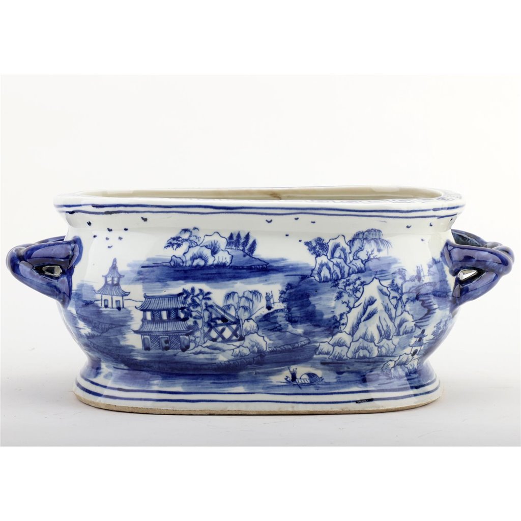 Blue and white ceramic dish with landscape design on a white background