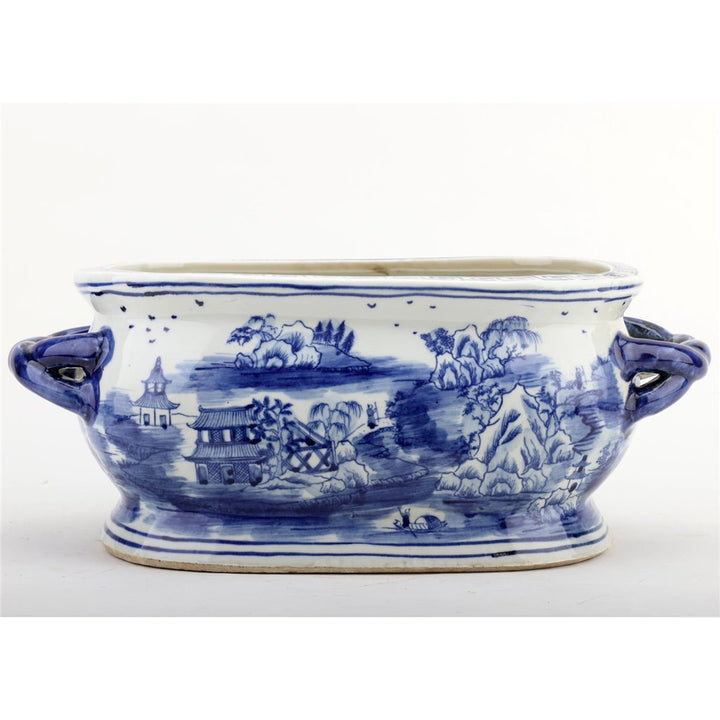 Blue and white ceramic dish with landscape design on a white background