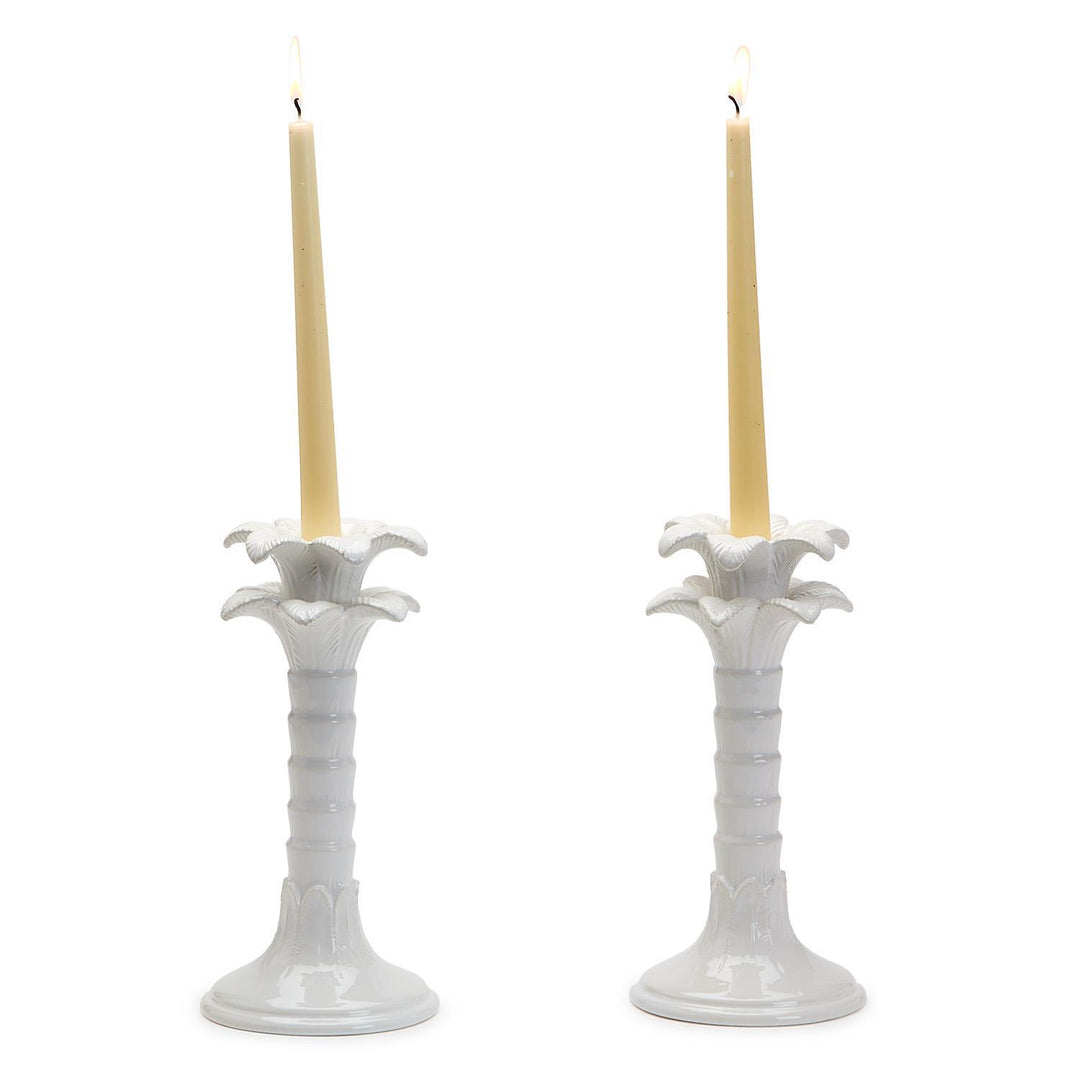 Two white candle holders with candles on a white background