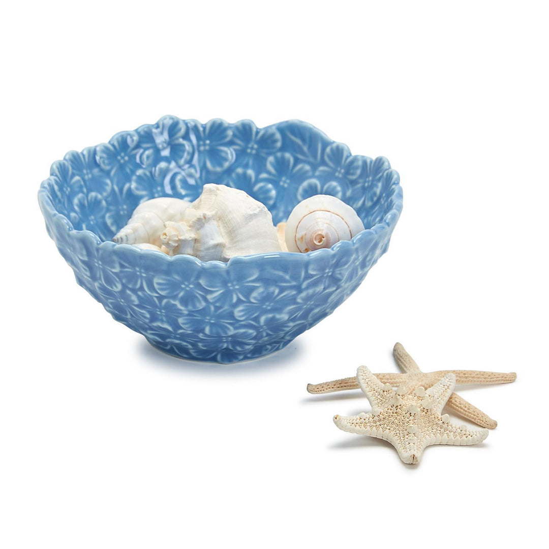 Blue decorative bowl with seashells and starfish on a white background