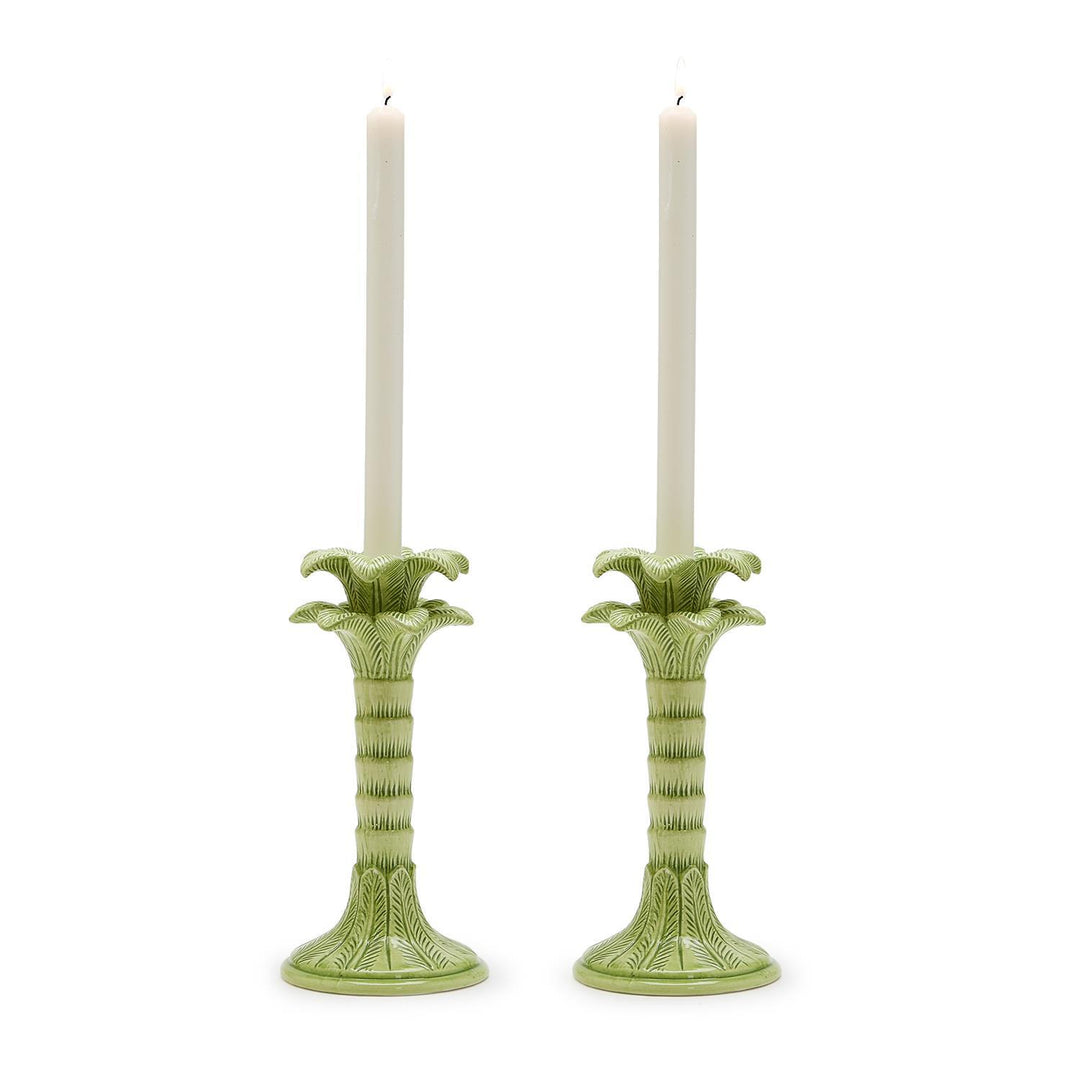 Green candle holders with candles on a white background