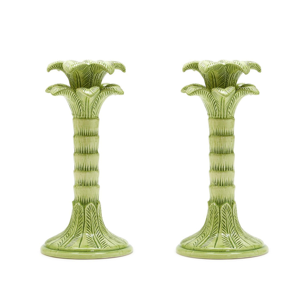 Two green ceramic candle holders on a white background