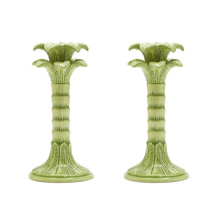 Two green ceramic candle holders on a white background