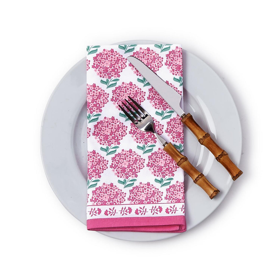 Floral-patterned napkin on a white plate with cutlery