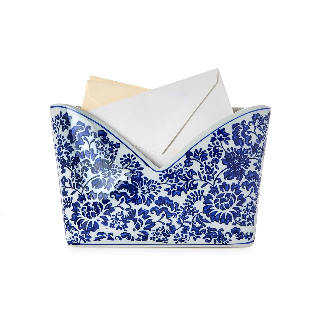 Decorative blue and white patterned holder with stationery items on a white background