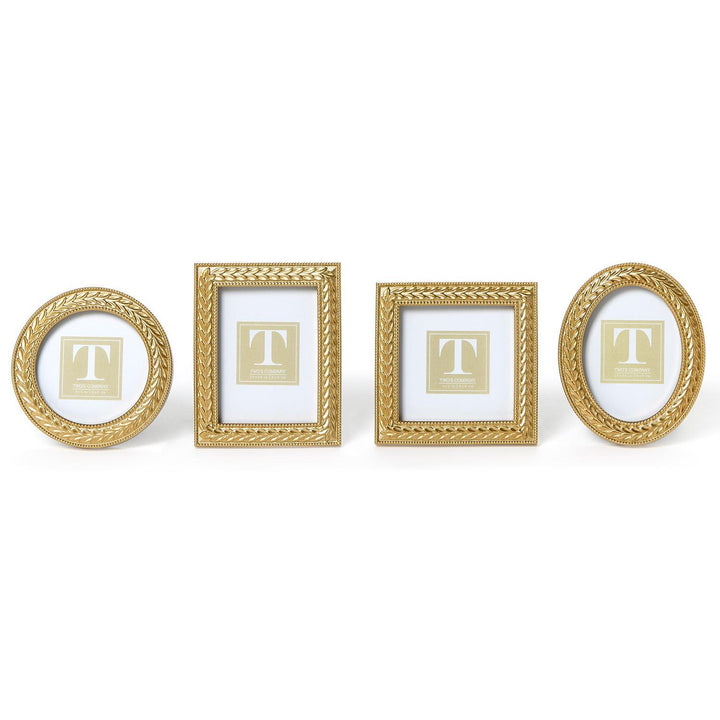 Set of four gold picture frames with 'T' monogram on a white background
