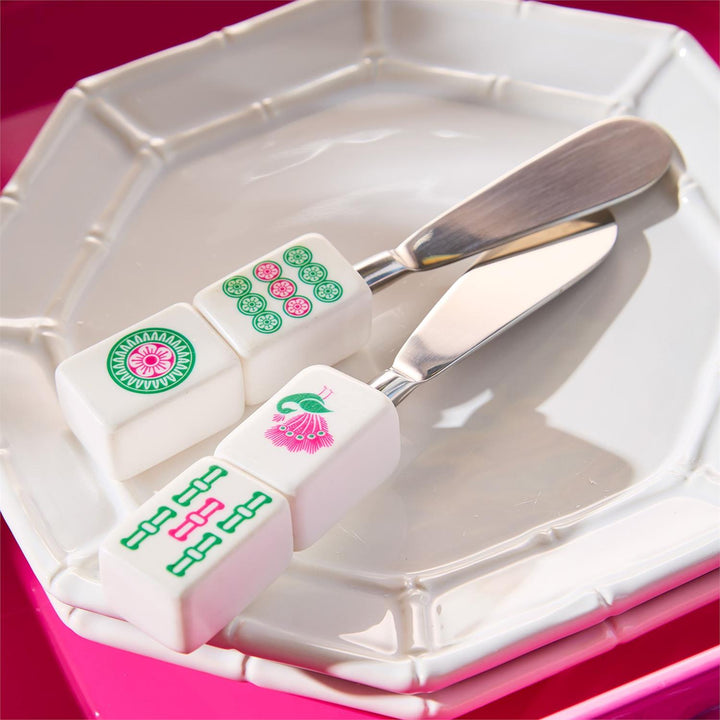 Two white rectangular blocks with pink and green designs on a white plate with a silver knife.