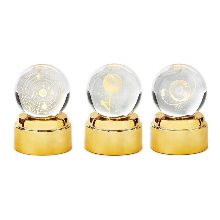 Three crystal balls with gold bases on a white background