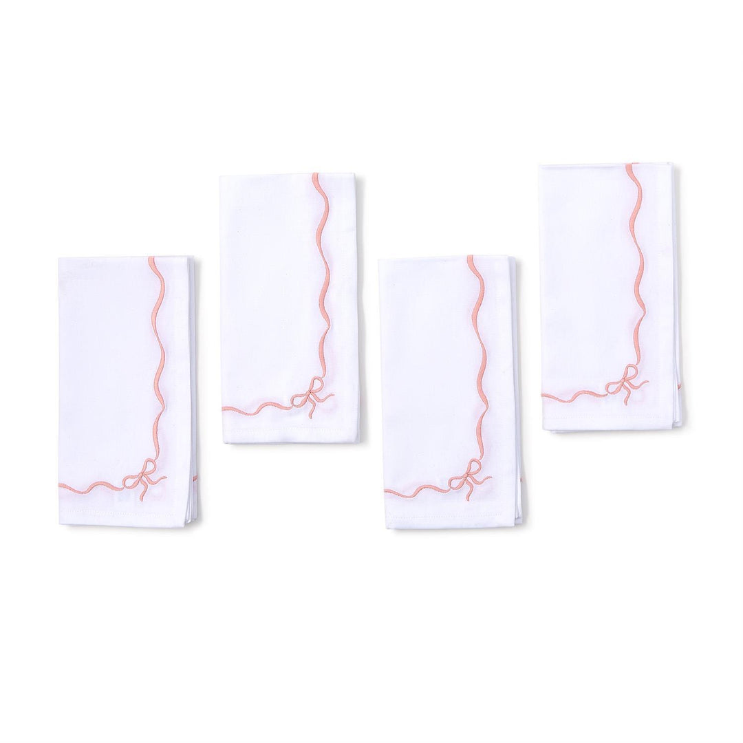 4 white napkins with pink wavy line design on a white background