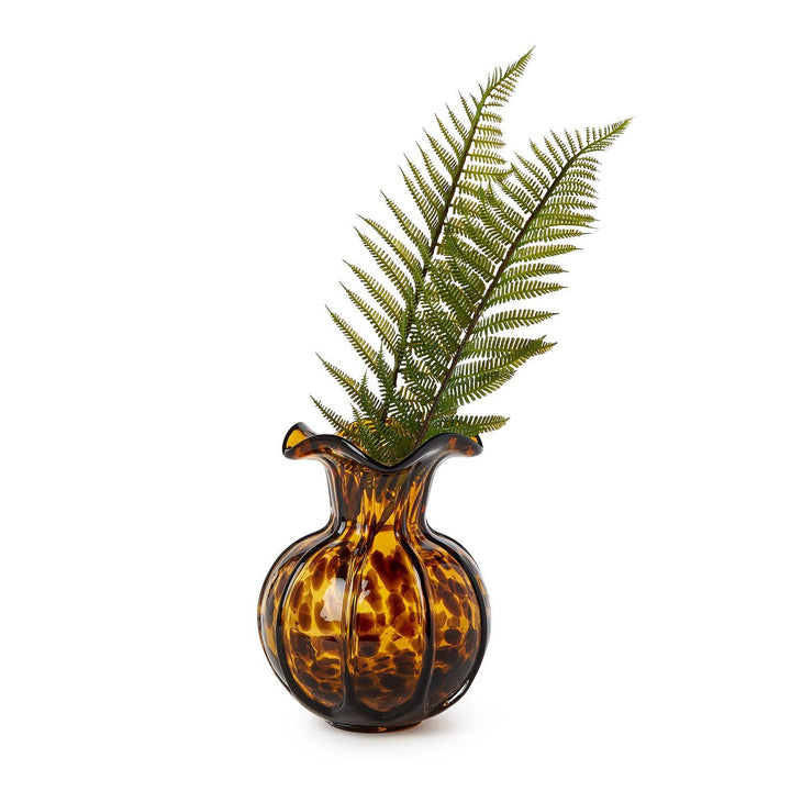 Tortoiseshell-patterned vase with a fern on a white background