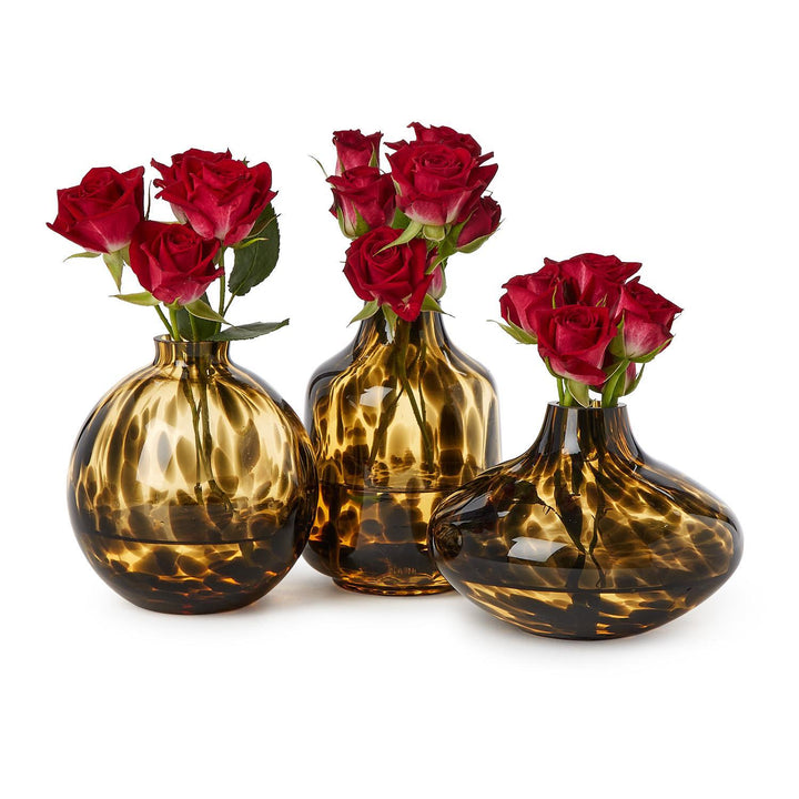 Three brown glass vases with red roses on a white background