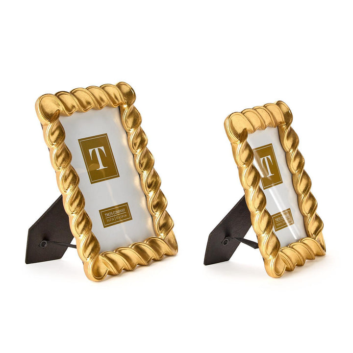 Two gold picture frames with a white center on a white background