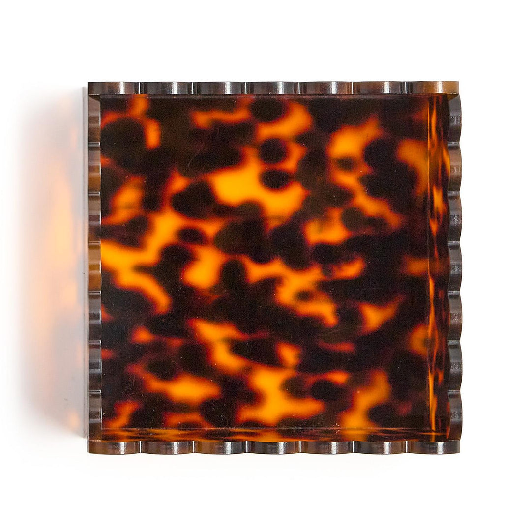 Tortoiseshell-patterned wall sconce with metallic frame on a white background
