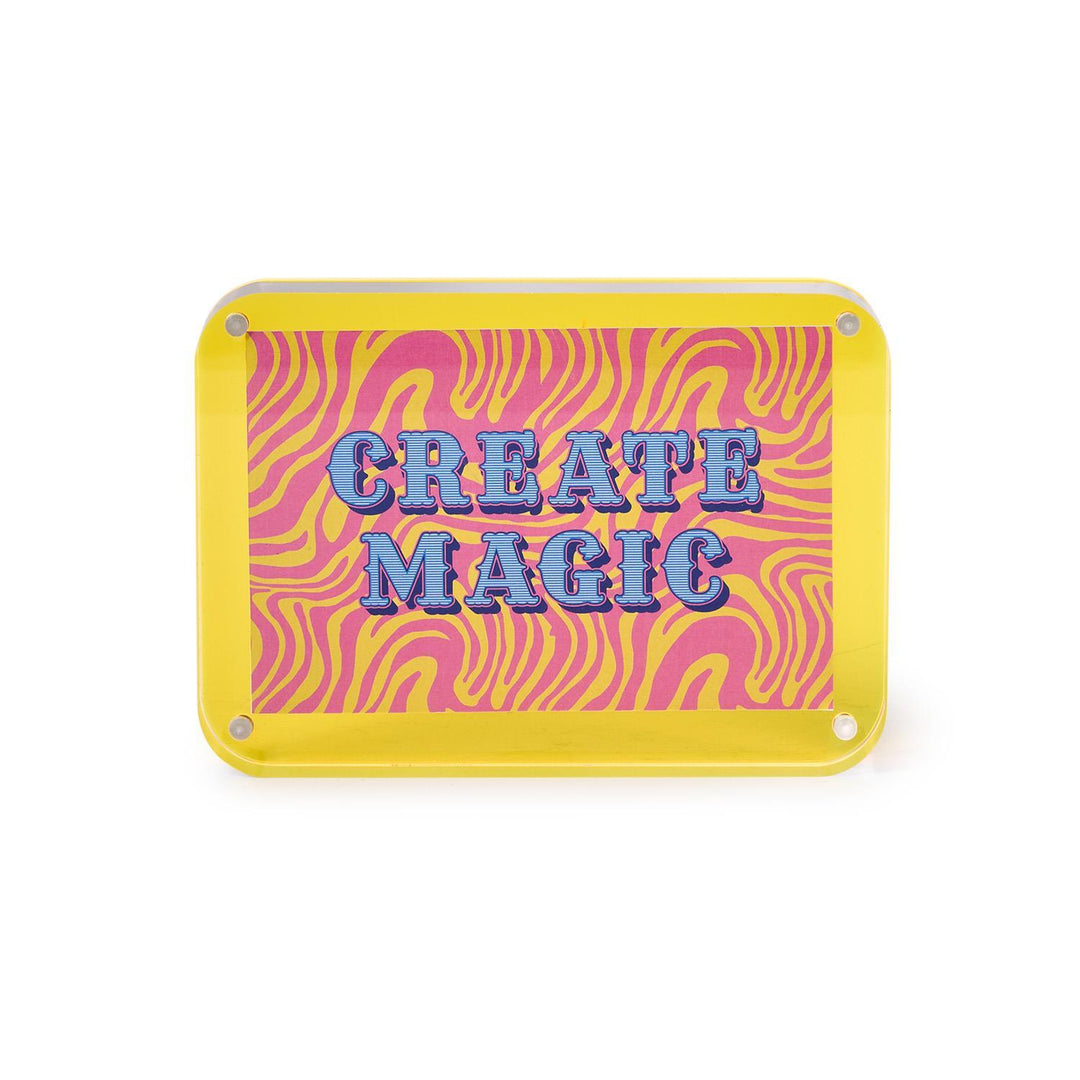 Rectangular sign with pink and yellow zebra pattern and 'CREATE MAGIC' text on a white background