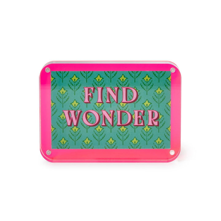 Rectangular sign with 'Find Wonder' text on a green patterned background with pink border