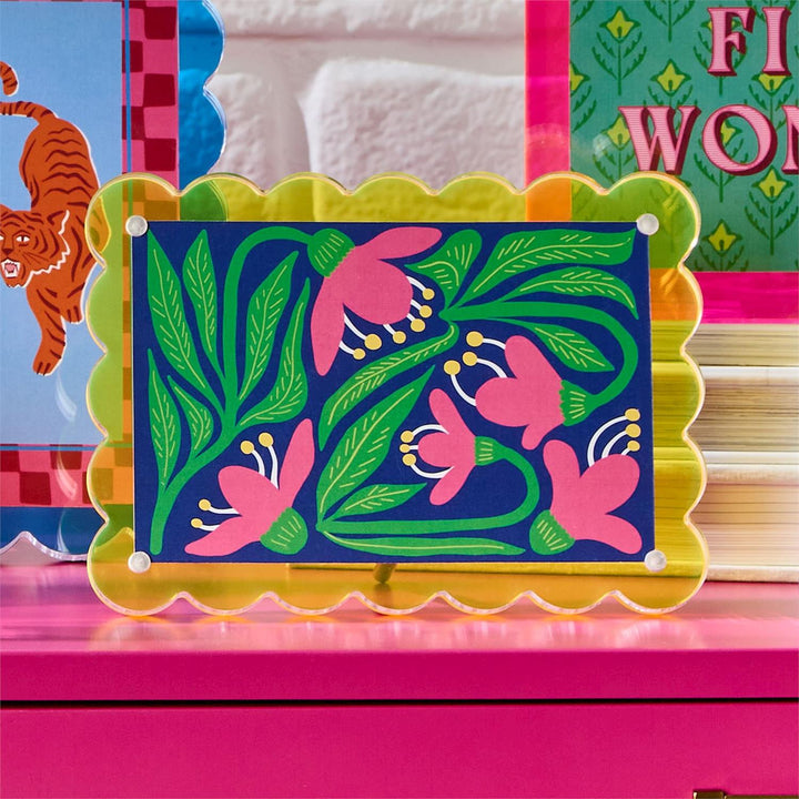 Colorful floral design on a rectangular board with a pink border, placed on a pink surface.