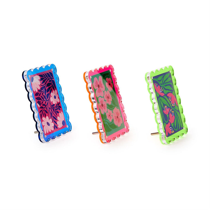 Three colorful floral earrings with different frame designs on a white background