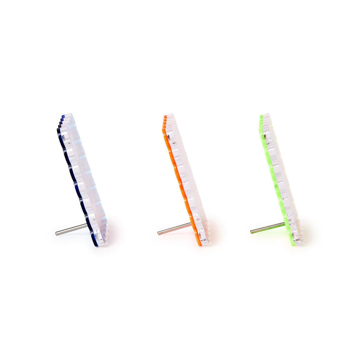 Three small cylindrical objects with colorful bands on a white background