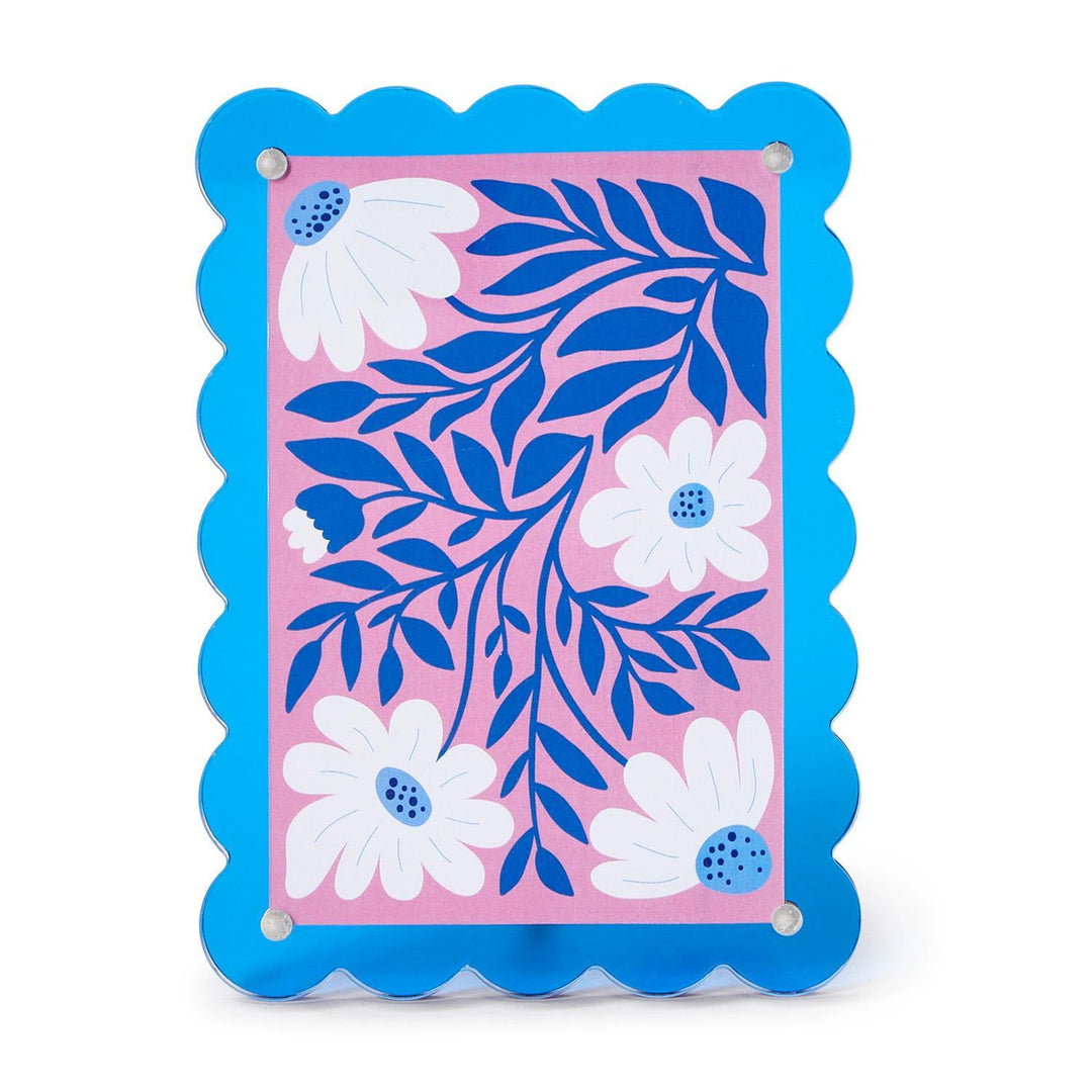 Decorative wall art with blue floral design on a pink background