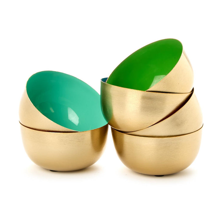 Two gold and green egg-shaped containers on a white background