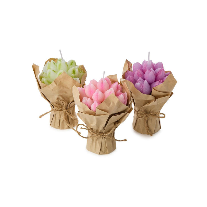 Three wrapped candles in green, pink, and purple on a white background