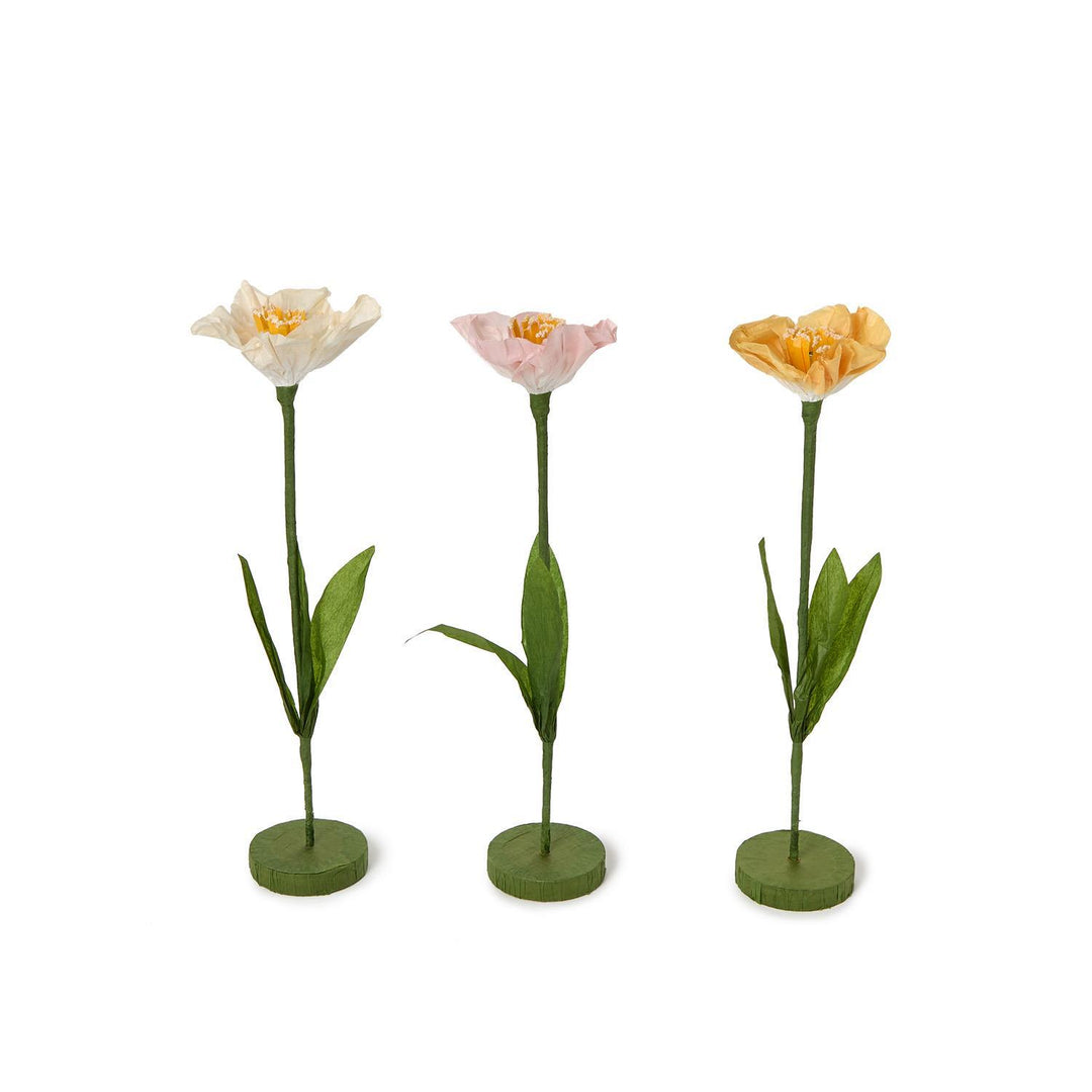 Three artificial tulip flowers in white, pink, and yellow on a white background