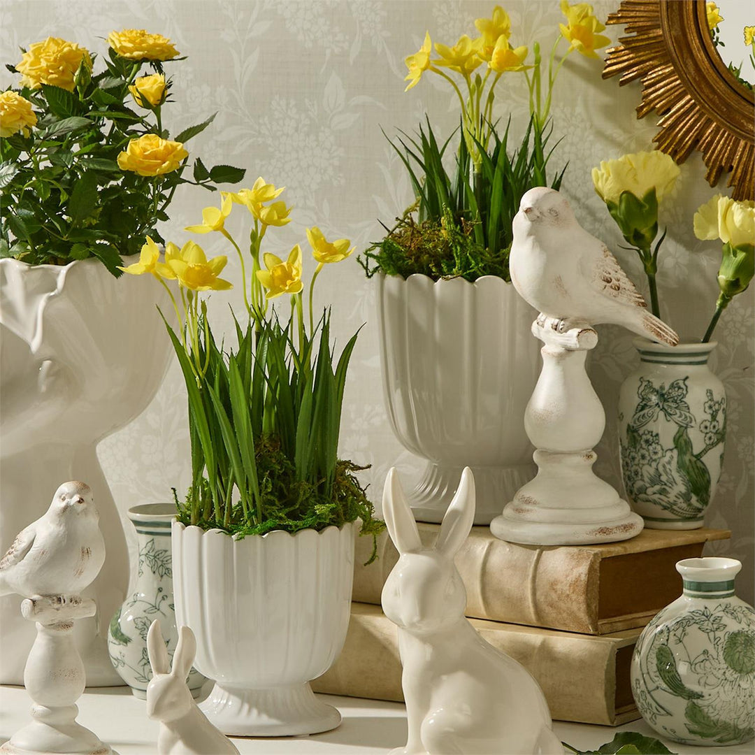 Decorative scene with potted plants, vases, and ceramic animals on a light background