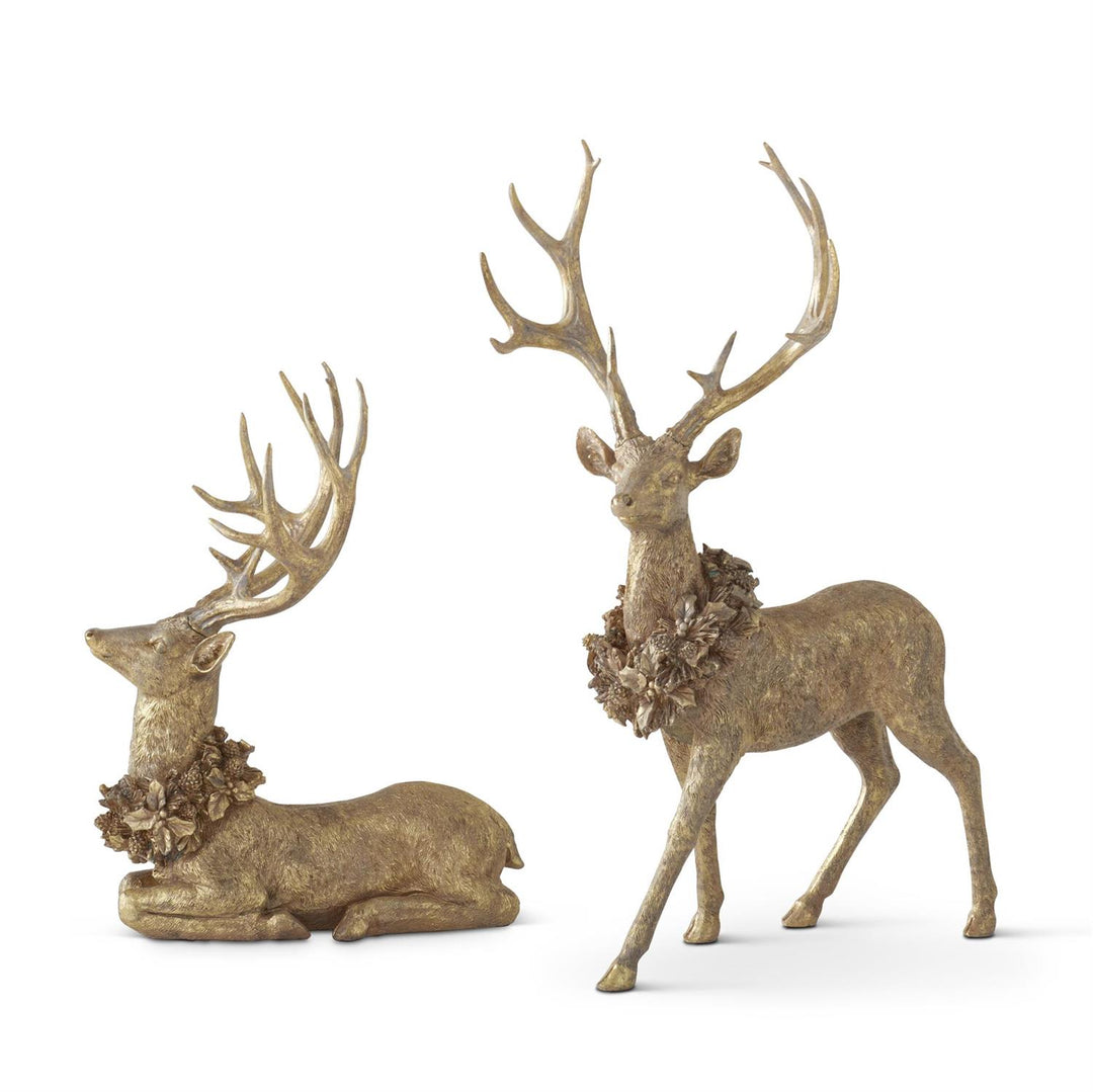 Two decorative deer statues with floral wreaths on a white background