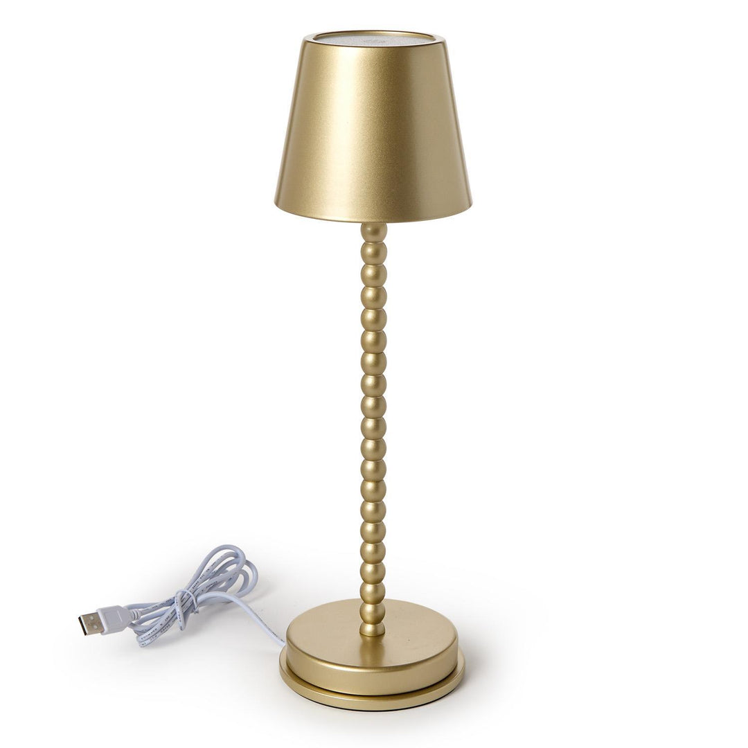 Gold table lamp with USB cable on a white background