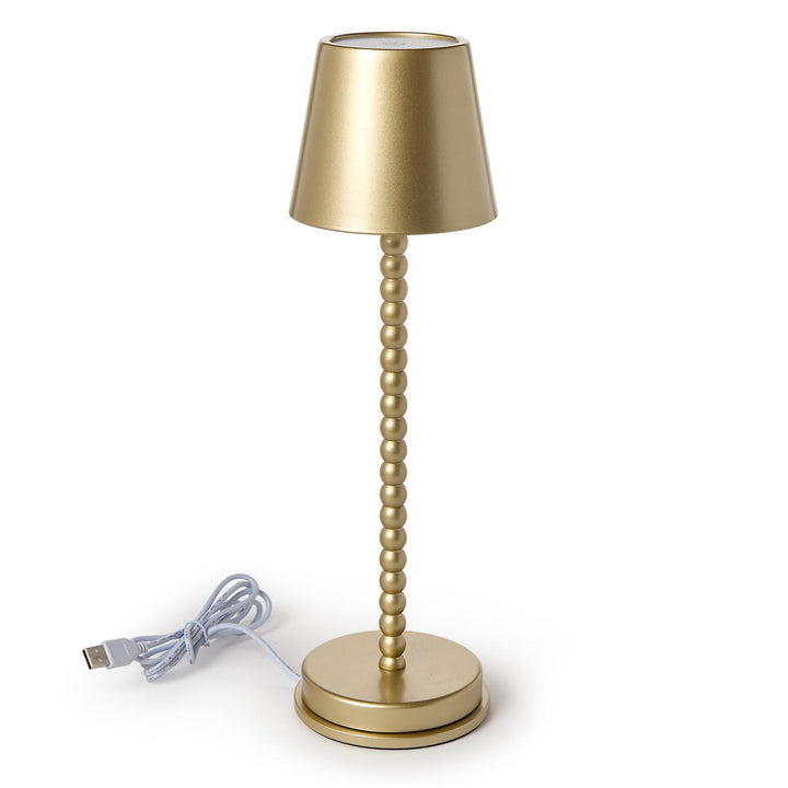 Gold table lamp with USB cable on a white background