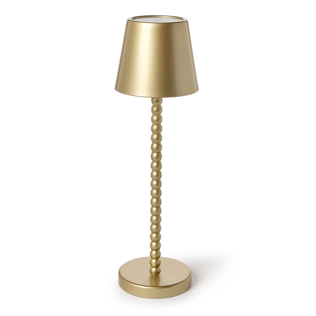 Gold table lamp with a textured stem on a white background