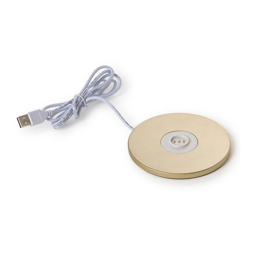 Round beige wireless charging pad with USB cable on a white background