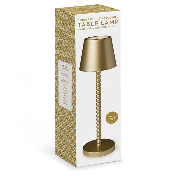 Gold table lamp with packaging on a white background