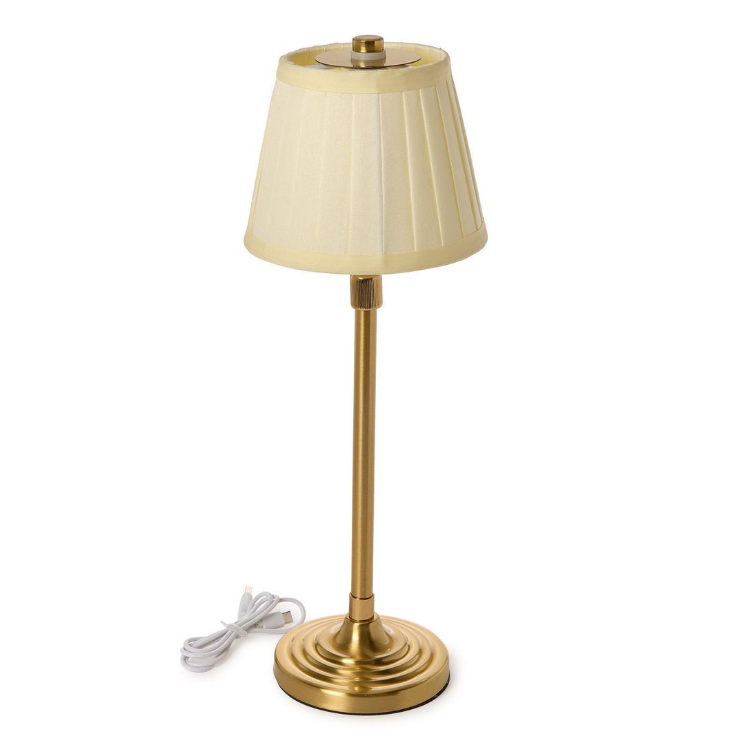 Gold table lamp with a beige pleated shade on a white background