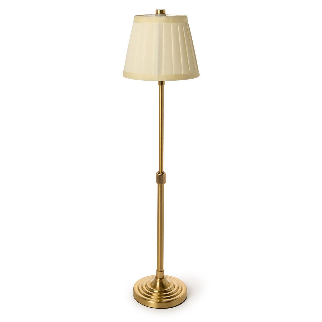Gold floor lamp with a beige shade on a white background