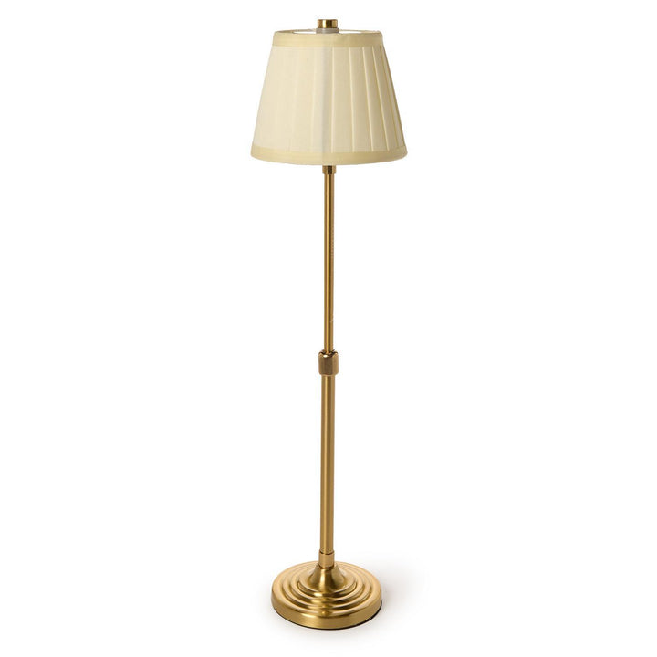 Gold floor lamp with a beige shade on a white background