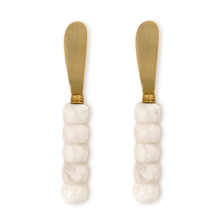 Two butter knives with marble handles and gold accents on a white background