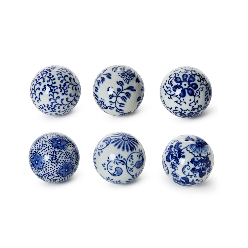 Six ceramic balls with blue floral patterns on a white background