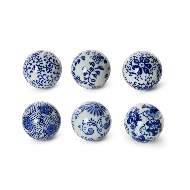 Six ceramic balls with blue floral patterns on a white background
