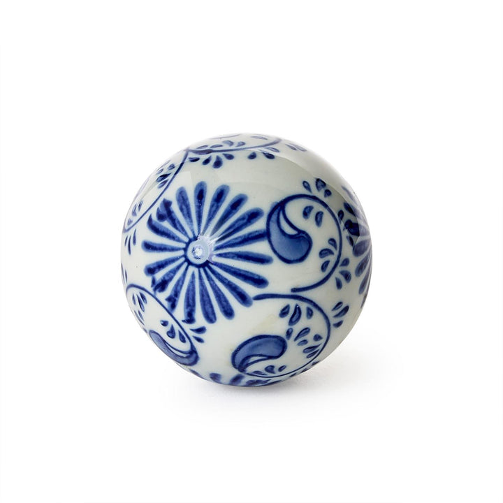 Decorative ceramic ball with blue floral patterns on a white background